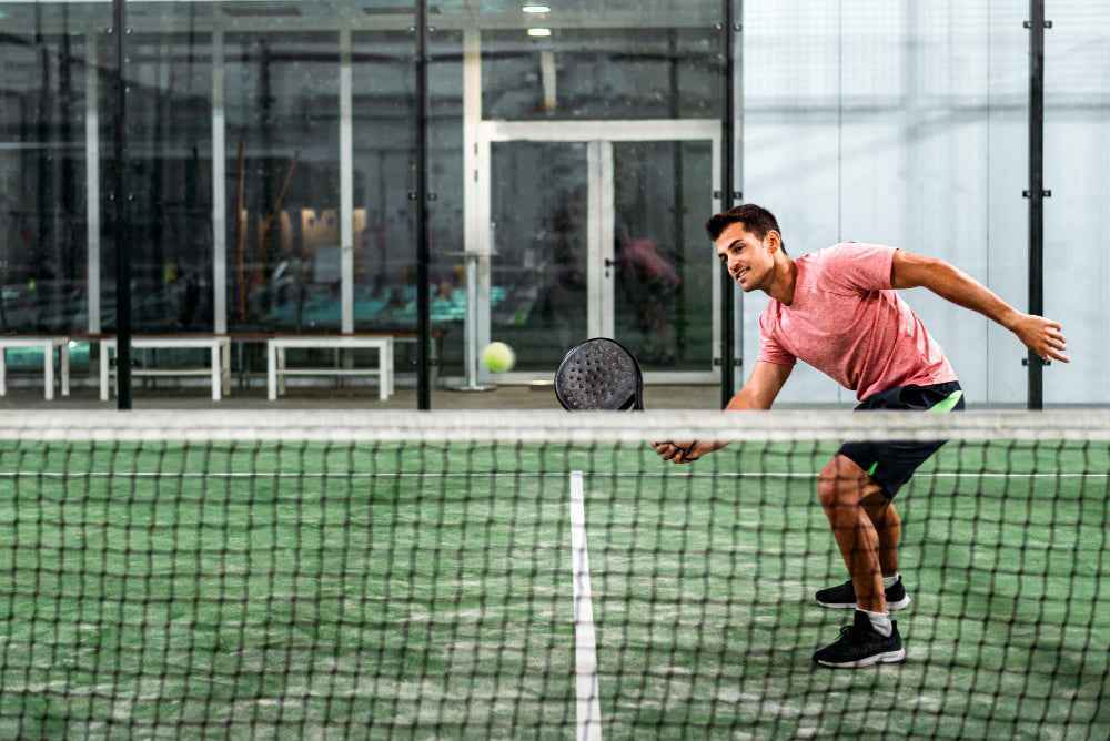 Padelspeler duikt naar de bal bij het net